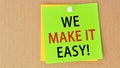 Phrase we make it easy written on green paper and pinned on corkboard, concept