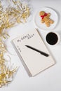 Phrase My Goals 2024 in a notebook, pen. Mug of coffee, gingerbread man and tinsel. Top view