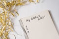 Phrase My Goals 2024 in a notebook. Tinsel on white background. Close up