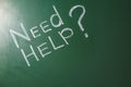 Phrase `Need help?` written on green chalkboard.