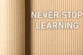 Phrase NEVER STOP LEARNING on corrugated cardboard