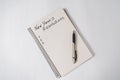 Phrase New Year`s resolutions in the notebook and blank page, pen