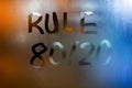 The phrase rule 80 by 20 - pareto principle - handwritten on classic blue night wet window glass with selective focus