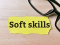 Phrase Soft skills written on yellow torn paper with eye glasses.