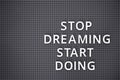 Phrase Stop Dreaming Start Doing spelled out with white letters on gray pegboard