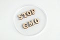 The phrase STOP GMO is folded from wooden letters into a petri dish. Laboratory. White background. Copy space. Concept of protest Royalty Free Stock Photo