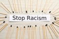 Phrase Stop Racism and different matches on white wooden table, flat lay Royalty Free Stock Photo