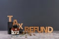 Phrase TAX REFUND, model of house and money on table against grey background Royalty Free Stock Photo