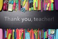 Phrase Thank You Teacher and different school stationery on blackboard, flat lay Royalty Free Stock Photo