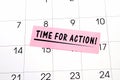The phrase time for action written in black text on a pink sticky note posted to a calendar page as a reminder. Close up of a Royalty Free Stock Photo