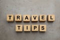 Phrase Travel Tips made with wooden cubes on grey table, flat lay