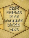 Phrase Two Heads Are Better Than One make by black alphabet stamps on cardboard