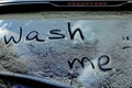 Phrase Wash me written on dirty car window outdoors, closeup Royalty Free Stock Photo