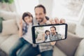 Phto portrait of handsome positive cheerful dad hugging embracing his son on couch taking selfie on telephone showing v