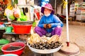 Phu Quoc, Vietnam, 26 February 2018 - Woman in traditional hat selling seafood on traditional street food market Royalty Free Stock Photo