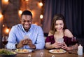 Phubbing. Young Interracial Couple Looking At Their Smartphones At Date In Restaurant Royalty Free Stock Photo