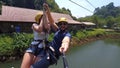 PHUKET, TAILAND - 08 FEV 2017: Great footage of a happy couple sliding down a zip line in tandem.