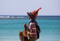 Close up of isolated female Thai beach vendor selling traditional colorful striped woven
