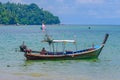 A fisherman sitting in his long tail boat