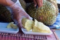 Phuket, Thailand food market: vendor cutting piece of fresh durian