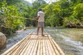 Phuket, Thailand - July 10, 2014. Man standing on bamboo raft and looking out