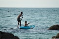 Phuket, Thailand-09 2019 2019-a little boy stands on a Windsurfing Board with a paddle. Evening light. Thailand, Phuket island Royalty Free Stock Photo