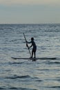 Phuket, Thailand-09 2019 2019-a little boy stands on a Windsurfing Board with a paddle. Evening light. Thailand, Phuket island Royalty Free Stock Photo