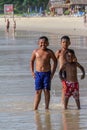 Local Asian children on the beach. Three boys playing in the waves. Royalty Free Stock Photo