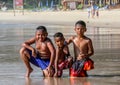 Local Asian children on the beach. Three boys playing in the waves. Royalty Free Stock Photo