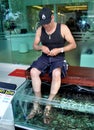 PHUKET, THAILAND: Man Getting Fish Foot Massage Royalty Free Stock Photo