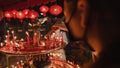 PHUKET, THAILAND - SEPTEMBER 24, 2022: Hand holding to light the red incense with flame of candle in the temple. Ritual, belief an Royalty Free Stock Photo