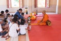 Phuket, Thailand, 04/19/2019 - Single buddhist monk praying with a family at the Chalong Temple