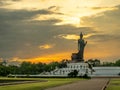 Phutthamonthon Buddha walking statue under evening cloudy sky in Thailand