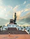 Phutthamonthon Buddha walking statue under evening cloudy sky in Thailand