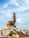 Phutthamonthon Buddha walking statue under evening cloudy sky in Thailand