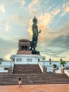 Phutthamonthon Buddha walking statue under evening cloudy sky in Thailand