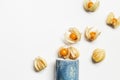 Physalis fruit or Physalis peruviana, small golden berries scattered from ceramic cup