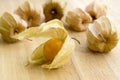 Physalis peruviana orange ripened fruits in husk on wooden table Royalty Free Stock Photo