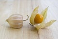 Physalis peruviana orange ripened fruits in husk on wooden table Royalty Free Stock Photo