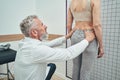 Physiatrist examining a lumbar spine of a female patient