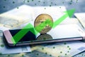 Bitcoin coin on the phone screen on the background of the Euro banknotes. Green arrow of the price growth chart Royalty Free Stock Photo