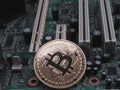 Physical bitcoin on computer motherboard Royalty Free Stock Photo