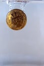 Physical bitcoin dropped in water Royalty Free Stock Photo
