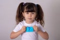 Thoughtful beautiful little girl, think, hesitate or have an intelligent idea or solution, grey background studio