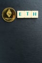 Physical Ethereum gold coin with letter tiles text