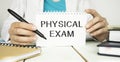 PHYSICAL EXAM card in hands of medical doctor, medical concept. Healthcare conceptual for hospital