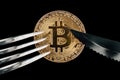 Physical Golden Crytocurrency Coin under fork and knive.