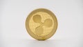 Physical metal golden Ripplecoin currency on white background. XRP coin