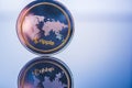 A physical ripple, cryptocurrency in gold and silver coin form on a blue studio background.