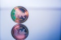 A physical ripple, cryptocurrency in gold and silver coin form on a blue studio background.